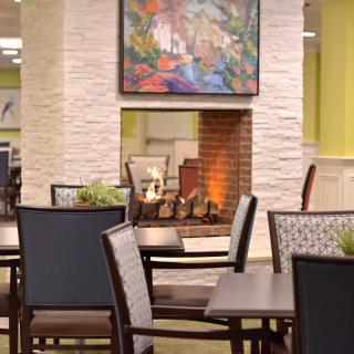 A cozy restaurant interior with a warm fireplace and elegant dining setup.