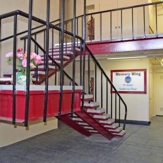 Interior view of a building entrance with a staircase and decorative flowers.
