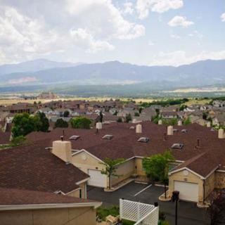 A suburban neighborhood with a scenic mountain view in the background under a cloudy sky.