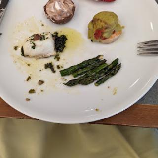 A beautifully plated dish featuring fish, asparagus, and various garnishes.