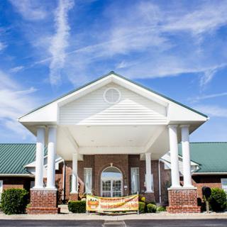 Front view of a building with columns and a brick facade under a clear blue sky.