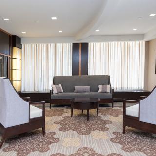 A stylish and modern living room interior with a sofa, chairs, coffee table, and patterned carpet.