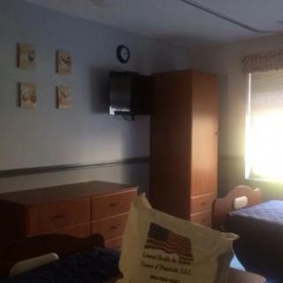 A cozy bedroom with essential furniture including a wardrobe, dresser, and television.