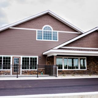 A modern building with large windows and a sloped roof.