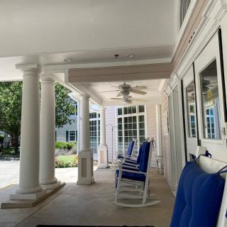 A serene porch with rocking chairs and white columns overlooking a garden.