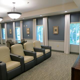 A modern home theater with comfortable seating and large windows.