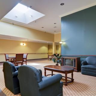 A cozy lobby area featuring comfortable seating, a skylight, and warm lighting.