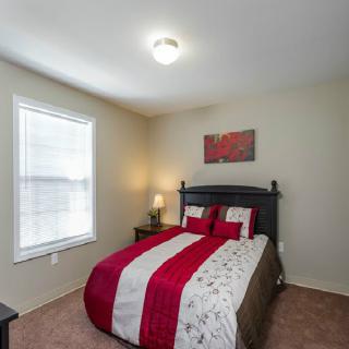 A cozy bedroom with a neatly made bed and warm lighting.