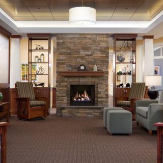 A cozy and modern living room with a stone fireplace and comfortable seating.