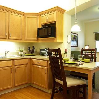 A cozy kitchen with wooden cabinets and a small dining area.