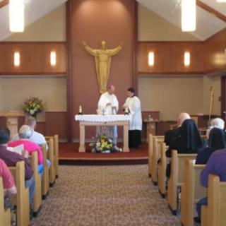 A church service with a priest conducting mass at the altar, attended by congregants.