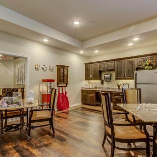 A modern kitchen and dining area with wood flooring, featuring sleek cabinetry and elegant furniture.