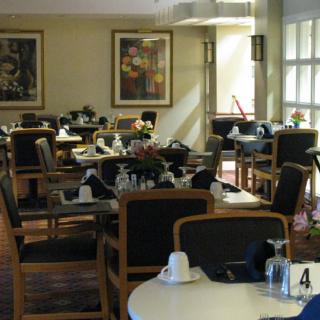 A well-arranged dining room with tables and chairs set for a meal.