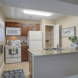 A modern kitchen interior with wood cabinets and white appliances.