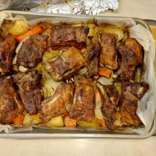 A baking dish filled with roasted meat and vegetables.