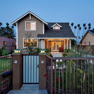 A charming residential house with a front garden and gate, captured in the evening.