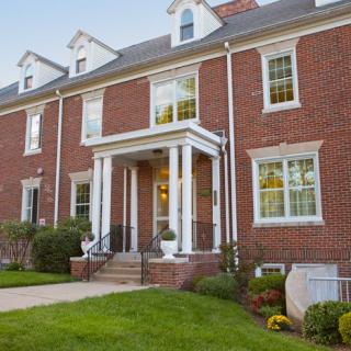 A traditional brick house with a well-maintained front lawn.