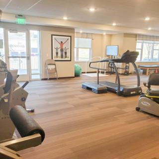 A spacious gym with modern exercise equipment including treadmills and stationary bikes.