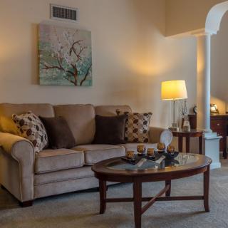 A cozy living room with a sofa, coffee table, and warm lighting.
