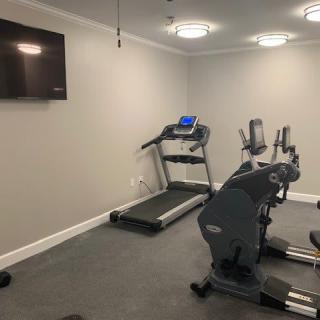 A small gym room featuring a treadmill and a stationary exercise bike.