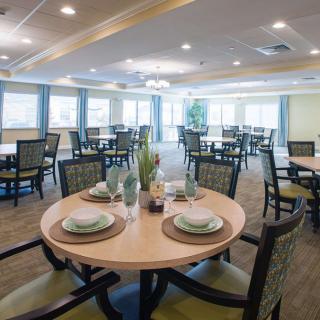 A spacious dining room with elegantly set tables and chairs.