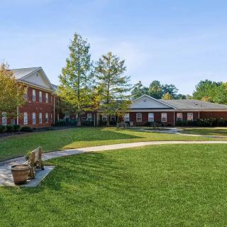 A picturesque view of a school campus with grassy areas and red-brick buildings.