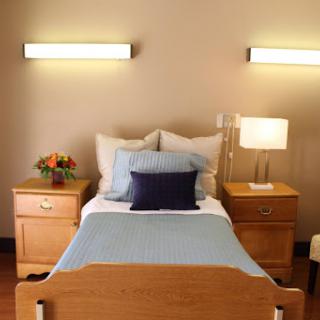 A cozy bedroom featuring a neatly made bed, stylish nightstands, and decorative lamps.