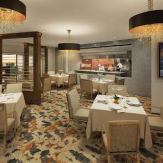 An elegant and cozy restaurant dining area with neatly arranged tables and chairs, featuring stylish decor and warm lighting.