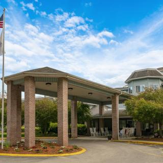 Entrance of a building with columns and an American flag nearby.