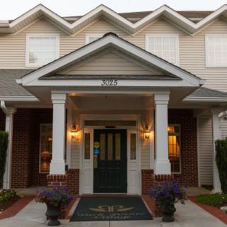 A welcoming front entrance of a house with pillars and overhanging roof.