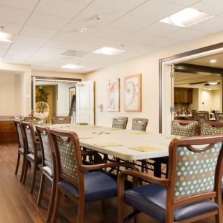 A well-lit conference room with a large table and several chairs, decorated in modern style.