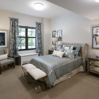 A modern bedroom with stylish decor and neutral color tones.
