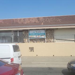 A view of a commercial building with visible signage and parked vehicles.