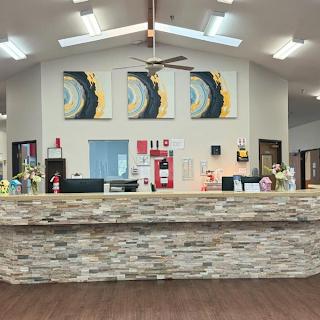 A modern reception area featuring a stylish stone counter and vibrant artwork.
