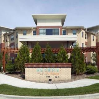 A modern apartment complex with landscaped greenery and a welcoming entrance.