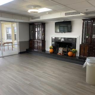 A spacious and modern living area featuring wooden cabinets, a television mounted on the wall, and decorative elements.