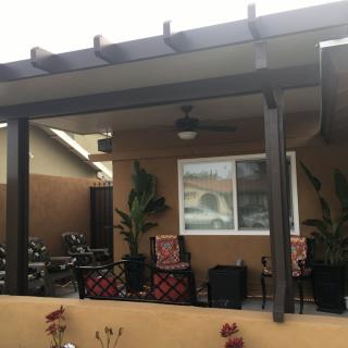 Cozy patio area with covered seating and decorative plants.