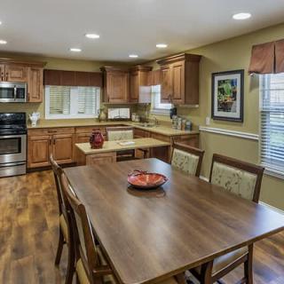 A spacious kitchen with wooden cabinets and a dining area featuring a large table and chairs.
