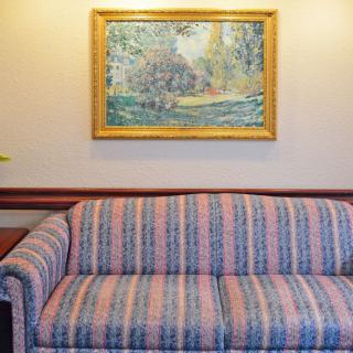 A cozy living room with a striped sofa and a framed painting on the wall.
