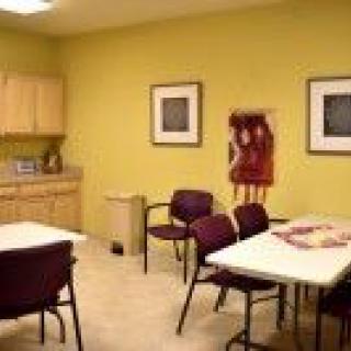 A breakroom with tables, chairs, and kitchen facilities.