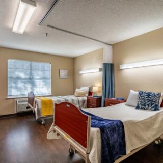 Hospital room interior with two patient beds and medical equipment.