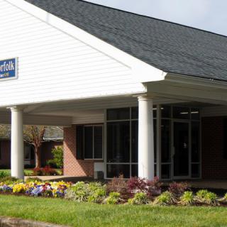 Exterior view of a bank building with landscaping and columns.