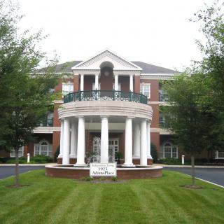 A grand building with large columns and a well-maintained lawn.