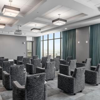 A modern conference room with comfortable seating and large windows.