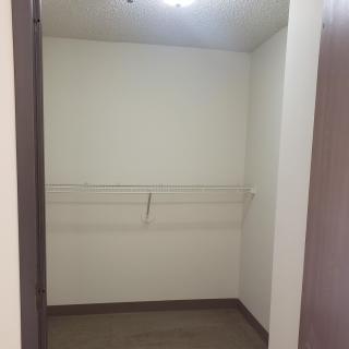 An empty, minimalist closet space with a light fixture.