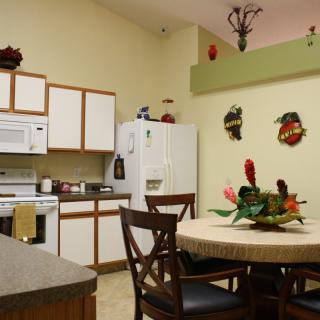 A cozy kitchen with a dining area, featuring a table with chairs and decorated walls.