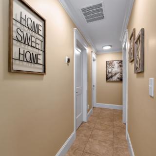 A cozy hallway with warm lighting and decor, featuring a 'Home Sweet Home' sign.
