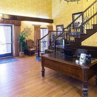 A hotel lobby featuring a wooden staircase and reception desk.
