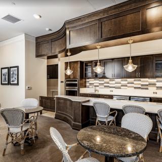 A modern kitchen and dining area with wood cabinets, pendant lighting, and granite countertops.