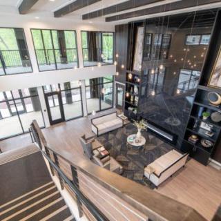 A spacious, modern living room with large windows and minimalist decor.